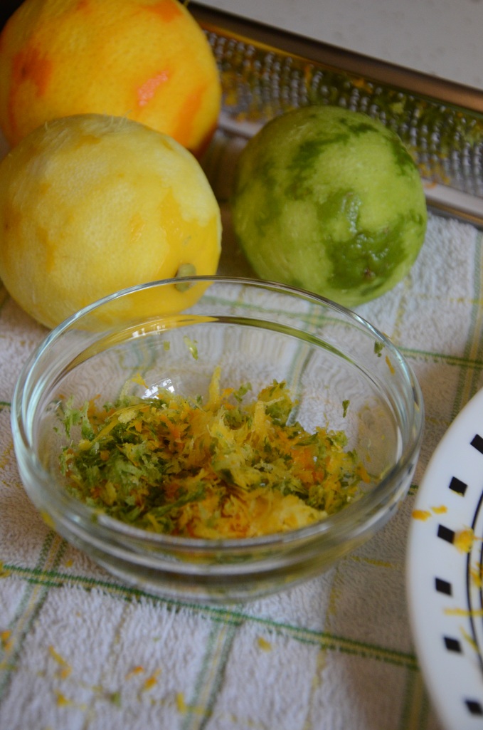 Colorful zest sits in a bowl with orange, lemon and lime.